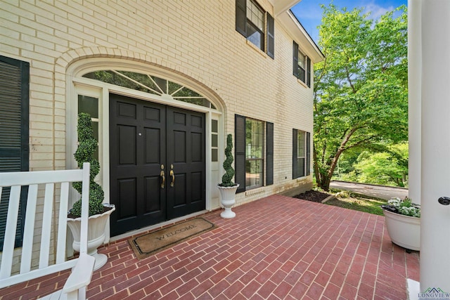 view of exterior entry with brick siding
