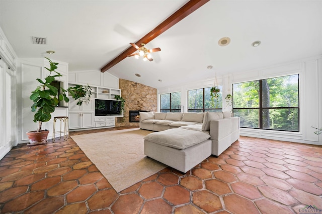 living room featuring visible vents, vaulted ceiling with beams, ceiling fan, built in features, and a stone fireplace