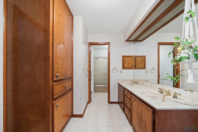 full bath featuring double vanity, baseboards, shower / bath combination with glass door, and a sink