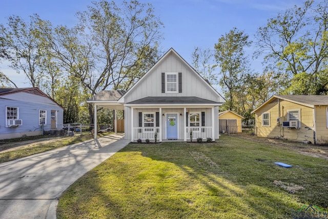 view of front of home with cooling unit, covered porch, a front yard, and a carport