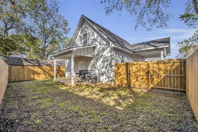 rear view of house with a lawn and a patio