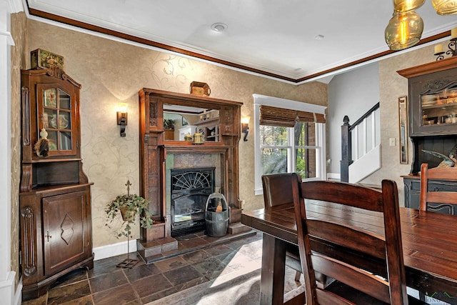 dining room featuring a tile fireplace and crown molding