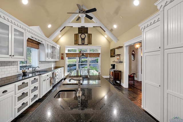 kitchen with decorative backsplash, sink, white cabinets, and ceiling fan