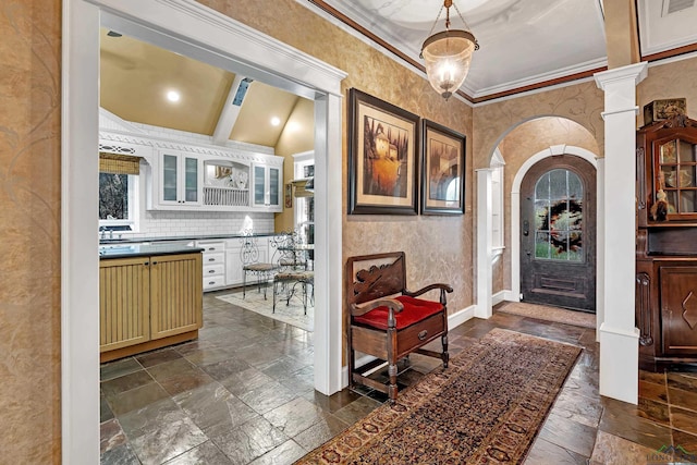 foyer with beam ceiling, decorative columns, high vaulted ceiling, and ornamental molding