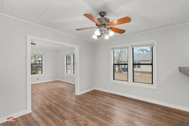 spare room with ceiling fan, crown molding, and wood-type flooring