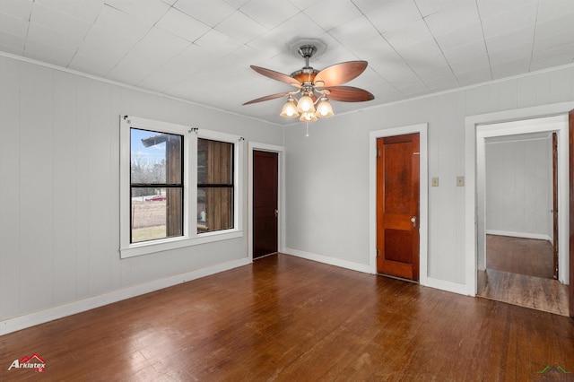 empty room featuring ceiling fan, dark hardwood / wood-style floors, and ornamental molding