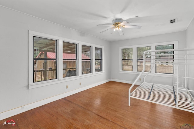 unfurnished sunroom featuring ceiling fan