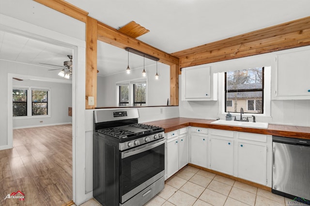 kitchen featuring white cabinets, hanging light fixtures, appliances with stainless steel finishes, and sink