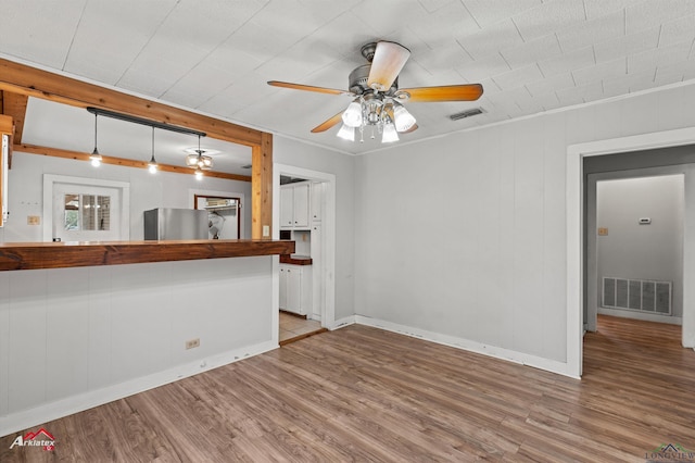 unfurnished living room with ceiling fan, hardwood / wood-style floors, and ornamental molding