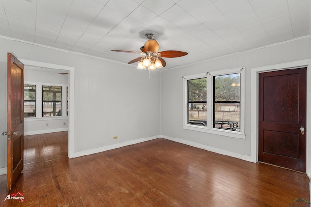 empty room featuring ceiling fan, dark hardwood / wood-style floors, and ornamental molding