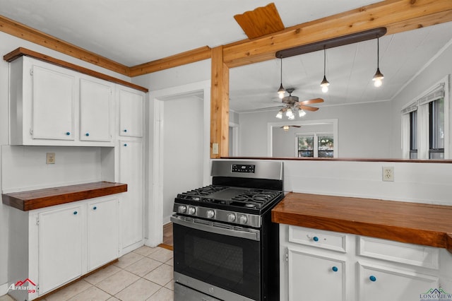 kitchen with pendant lighting, light tile patterned flooring, stainless steel range with gas stovetop, crown molding, and white cabinetry