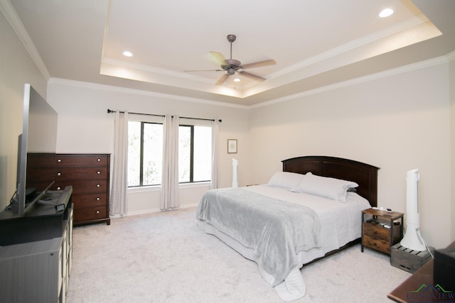 bedroom featuring a raised ceiling, ceiling fan, light colored carpet, and ornamental molding