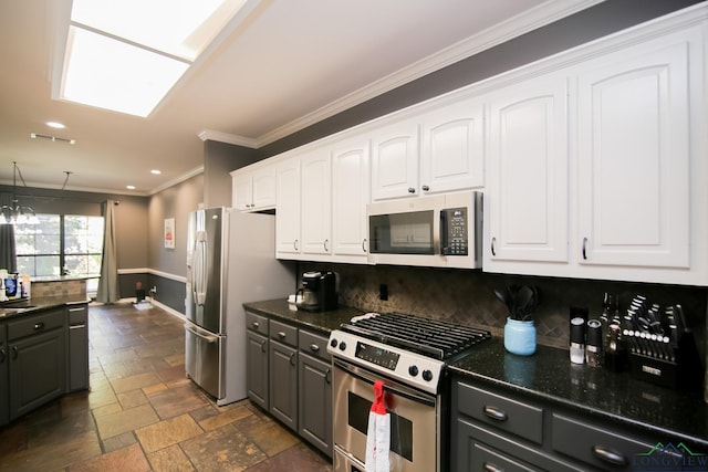 kitchen with white cabinetry, tasteful backsplash, a notable chandelier, appliances with stainless steel finishes, and ornamental molding