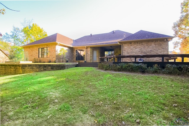 rear view of property featuring a lawn