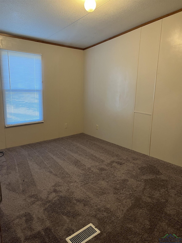 carpeted empty room featuring a textured ceiling