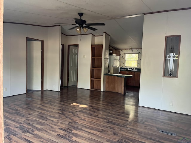 unfurnished living room with ceiling fan, lofted ceiling, and dark wood-type flooring