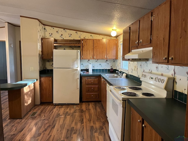 kitchen with lofted ceiling, white appliances, sink, a textured ceiling, and dark hardwood / wood-style flooring