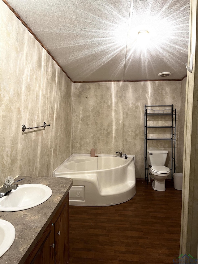 bathroom featuring wood-type flooring, a textured ceiling, toilet, and a tub