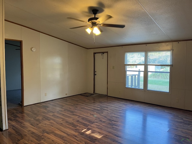 empty room with a textured ceiling, ceiling fan, ornamental molding, and dark wood-type flooring