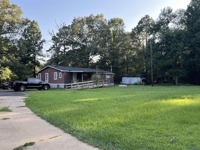 manufactured / mobile home featuring a shed and a front lawn