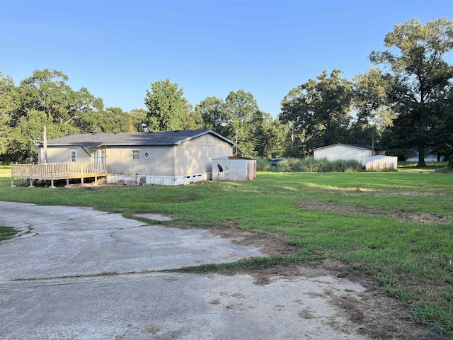 view of side of property with a yard and a deck