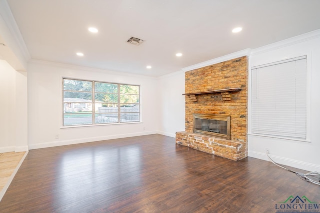 unfurnished living room featuring dark hardwood / wood-style flooring, a brick fireplace, and ornamental molding