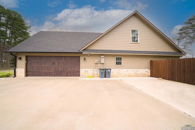415 Bob White Dr, Gilmer, TX 75645 - view of front of house with stone siding, a garage, and roof with shingles