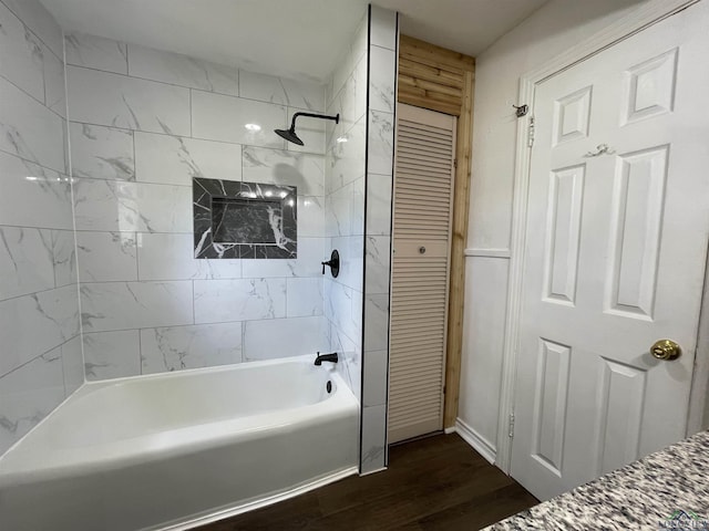bathroom with wood finished floors, shower / bathtub combination, and a closet