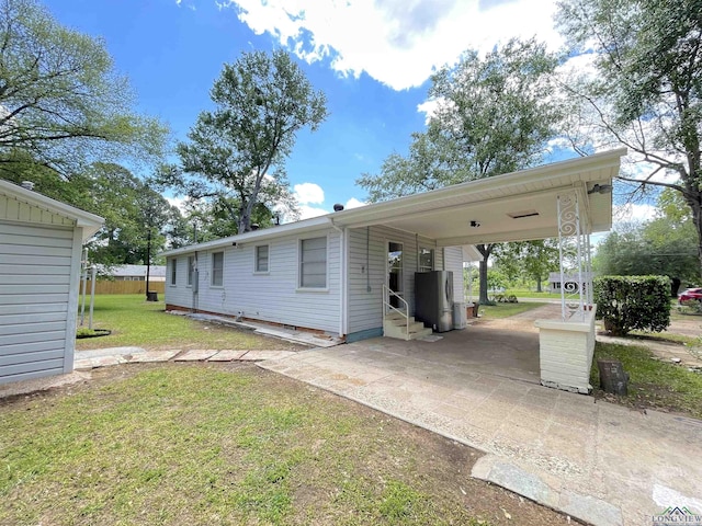 view of front of house featuring entry steps, a front yard, driveway, and a carport