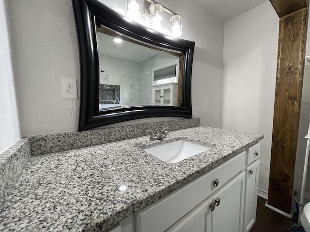 bathroom with a textured wall and vanity