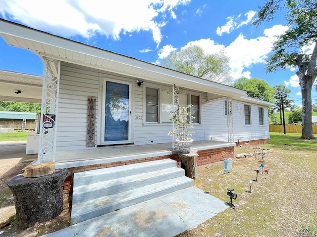 view of front of property featuring covered porch and fence