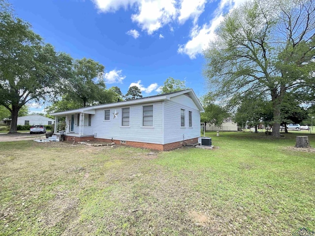 view of front of house with central AC and a front lawn