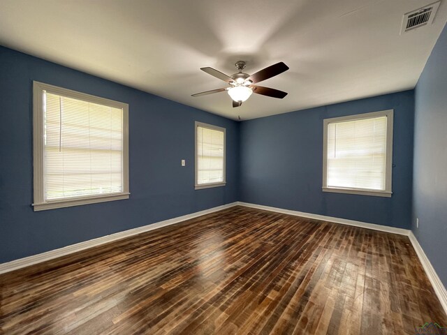spare room with dark wood-style flooring, baseboards, and ceiling fan