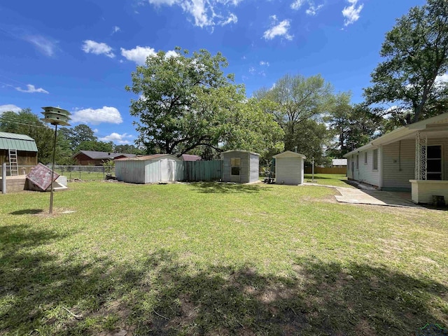 view of yard with a storage unit, an outbuilding, and a patio