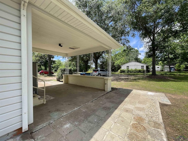 view of patio featuring concrete driveway and an attached carport