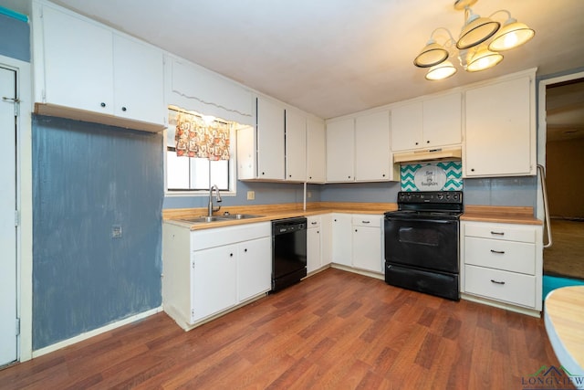 kitchen with under cabinet range hood, dark wood-style flooring, a sink, white cabinetry, and black appliances