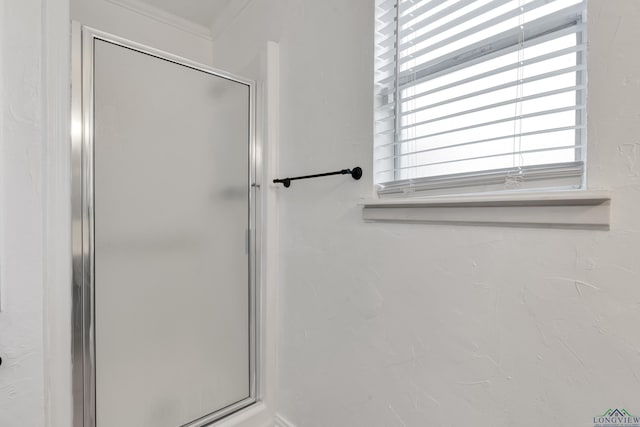 bathroom featuring a shower with shower door and ornamental molding