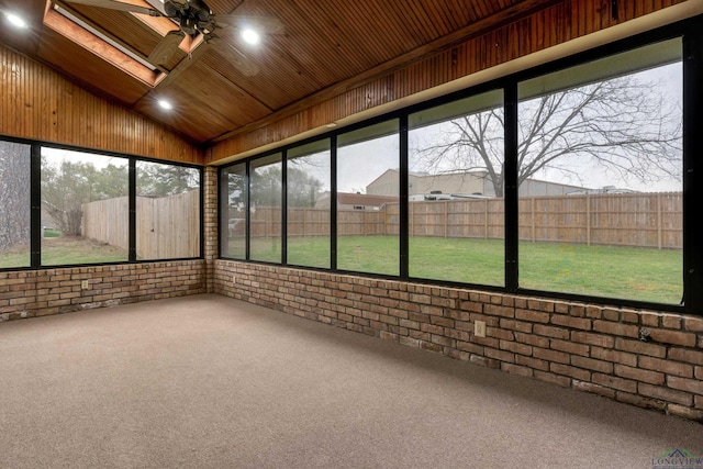 unfurnished sunroom featuring vaulted ceiling, ceiling fan, and wooden ceiling