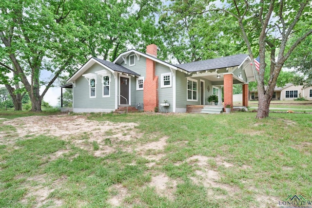 913 Church St, Winnsboro, TX 75494 - view of front of house featuring a chimney, entry steps, a shingled roof, covered porch, and a front yard