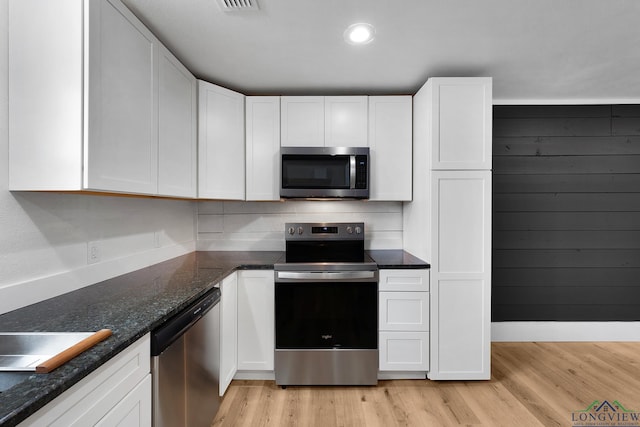 913 Church St, Winnsboro, TX 75494 - kitchen with appliances with stainless steel finishes, light wood finished floors, white cabinets, and recessed lighting