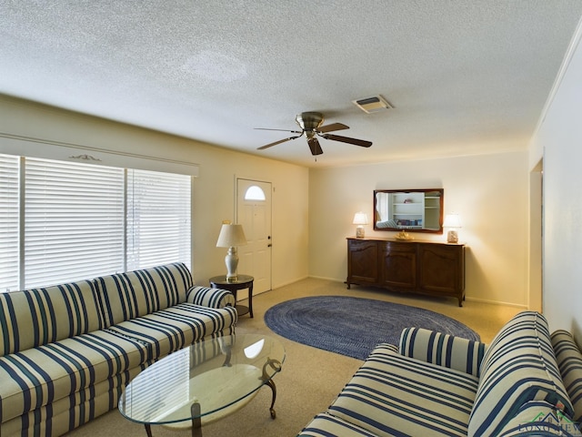 carpeted living room featuring ceiling fan and a textured ceiling