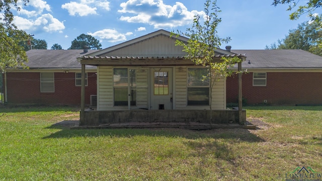 rear view of house featuring a yard