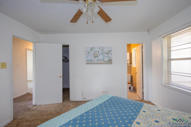 carpeted bedroom with connected bathroom, a closet, a spacious closet, and ceiling fan