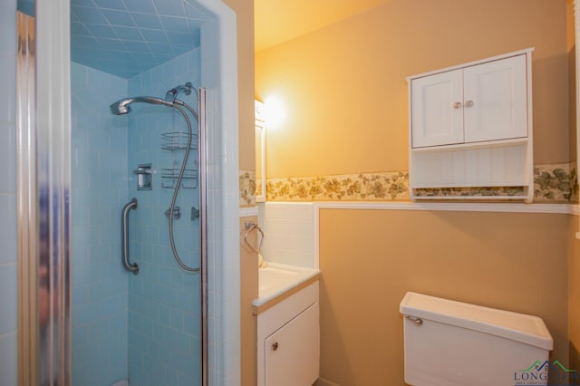 bathroom with vanity, toilet, and tiled shower