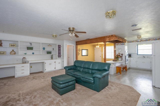 living room with sink, built in desk, and a textured ceiling