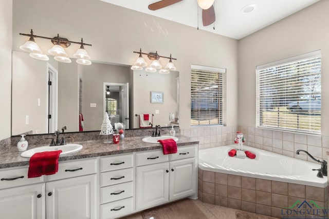 bathroom featuring tile patterned flooring, vanity, ceiling fan, and tiled bath