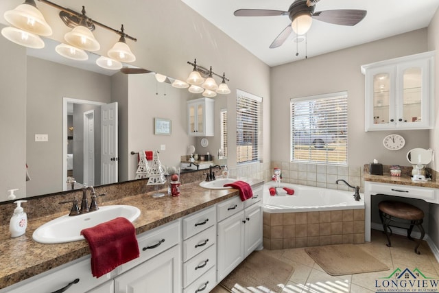 bathroom with tile patterned flooring, vanity, ceiling fan, and tiled tub