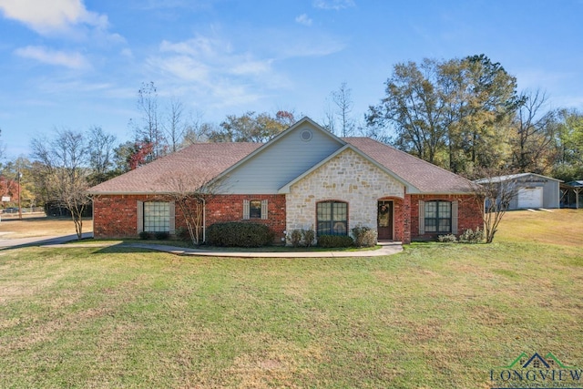 single story home featuring an outbuilding, a garage, and a front lawn