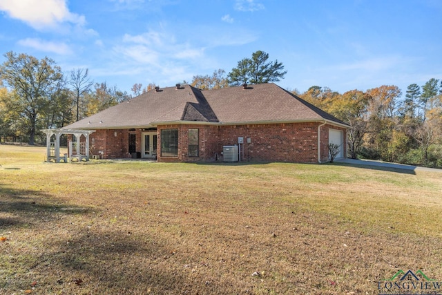 back of house with a lawn, a garage, and central AC