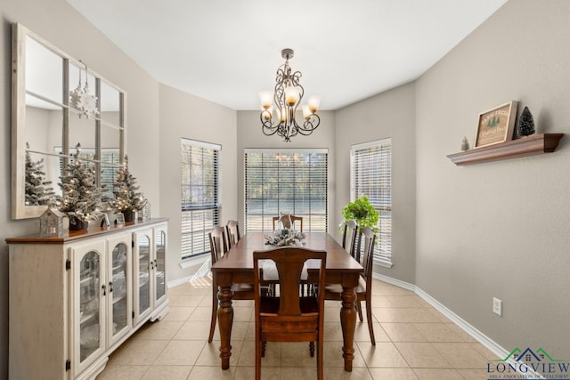 dining space with light tile patterned floors and a chandelier